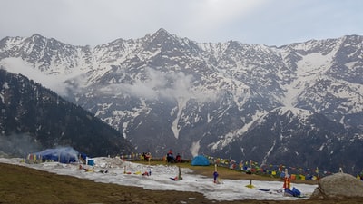 人在白天在山附近的海滩上冰雪覆盖
